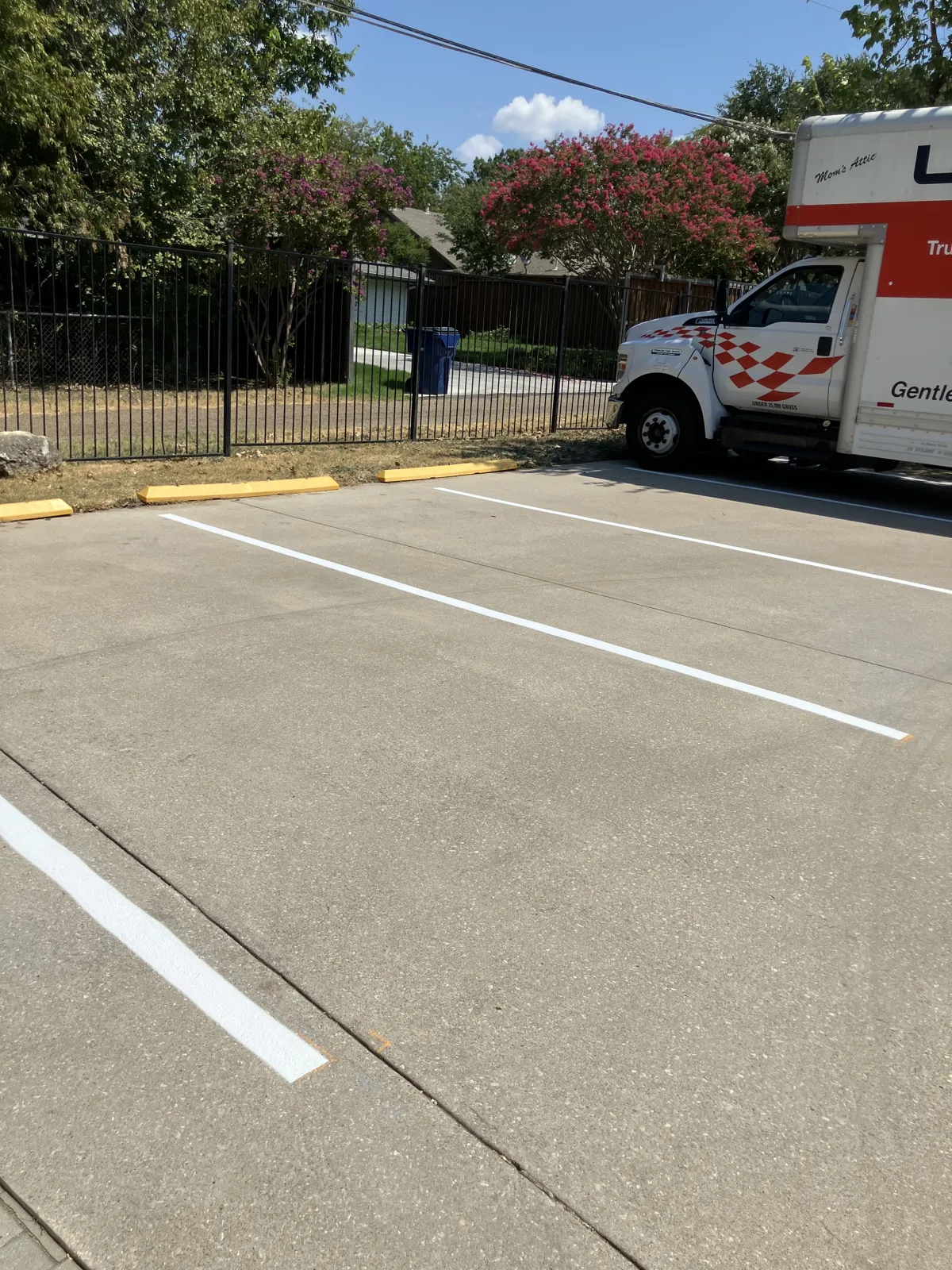 Brand-new white parking stall lines striped on a commercial lot in DFW